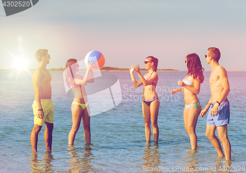 Image of smiling friends in sunglasses on summer beach