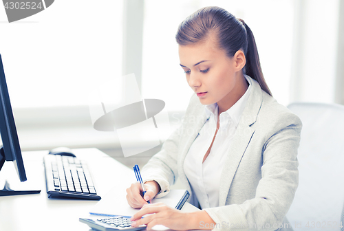 Image of businesswoman with notebook and calculator