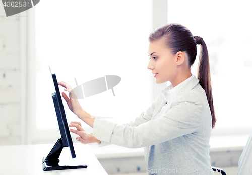 Image of smiling businesswoman with touchscreen in office