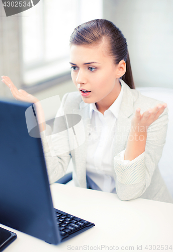 Image of stressed student with computer in office