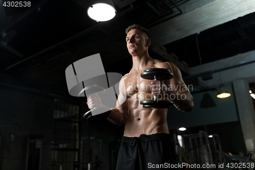 Image of close up of man with dumbbells exercising in gym