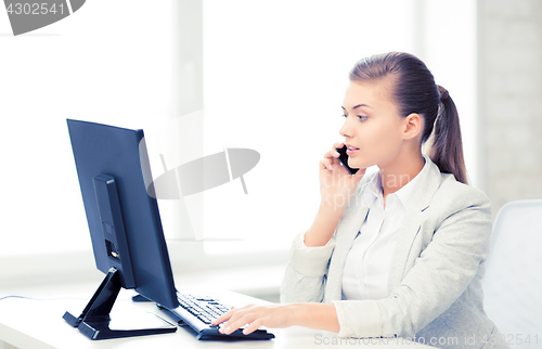 Image of businesswoman with smartphone in office