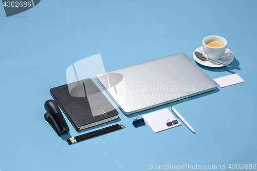 Image of The laptop, pens, phone, note with blank screen on table