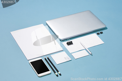 Image of The laptop, pens, phone, note with blank screen on table