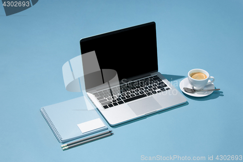Image of The laptop, pens, phone, note with blank screen on table
