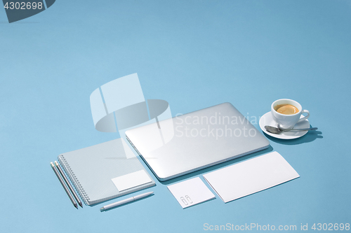 Image of The laptop, pens, phone, note with blank screen on table