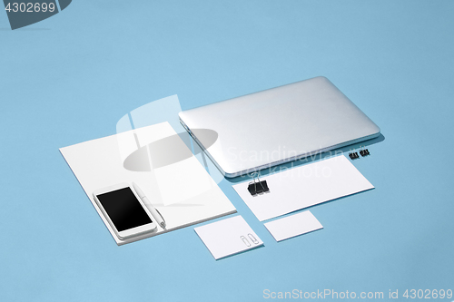 Image of The laptop, pens, phone, note with blank screen on table