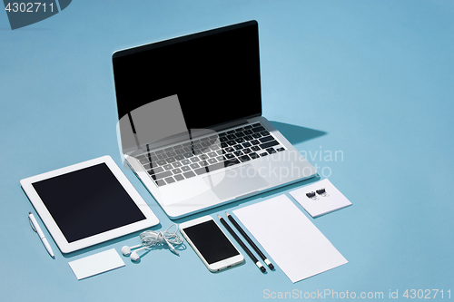 Image of The laptop, pens, phone, note with blank screen on table