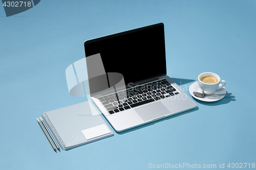 Image of The laptop, pens, phone, note with blank screen on table