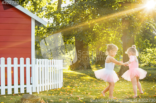 Image of The two little girls at playground against park or green forest