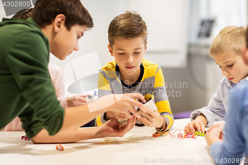 Image of happy children building robots at robotics school