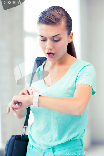 Image of surprised student girl looking at clock