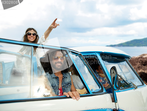 Image of happy hippie friends in minivan car on island