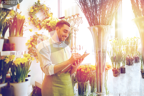 Image of florist man with clipboard at flower shop