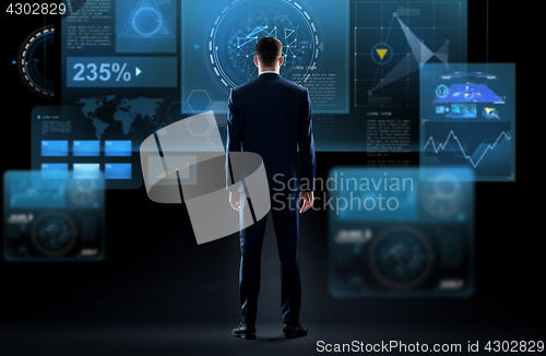 Image of businessman looking at virtual screen from back