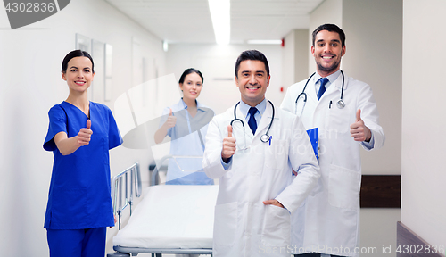 Image of happy doctors showing thumbs up at hospital