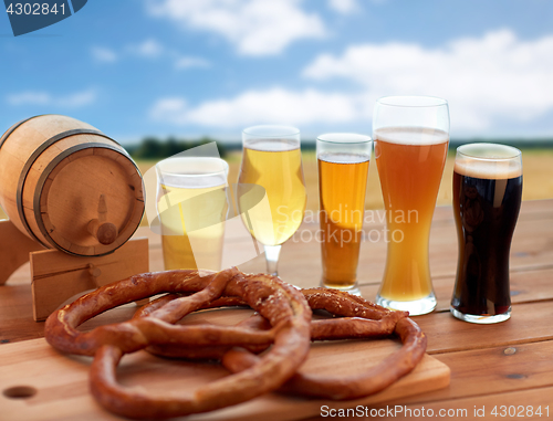 Image of beer glasses, barrel and pretzel over cereal field