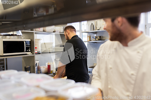 Image of chef and cook cooking food at restaurant kitchen