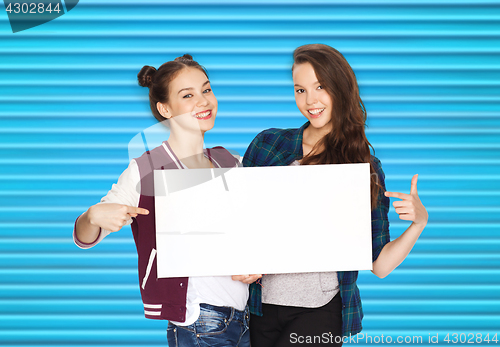 Image of smiling teenage girls holding white blank board