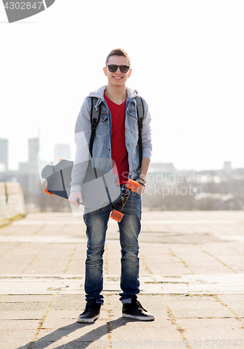 Image of happy young man or teenage boy with longboard