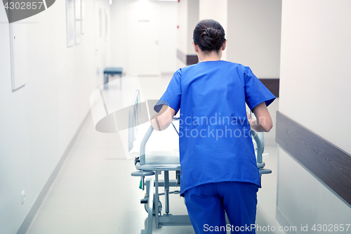 Image of nurse carrying hospital gurney to emergency room