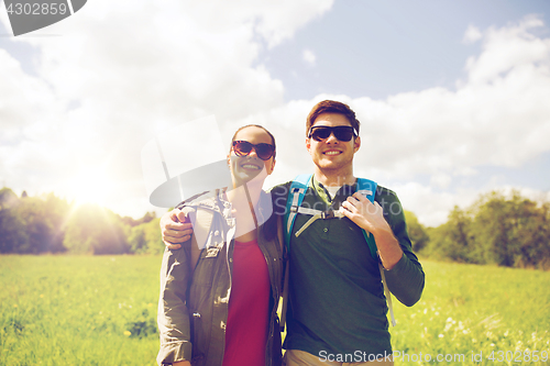 Image of happy couple with backpacks hiking outdoors