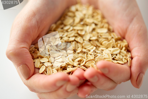 Image of close up of hands holding oat flakes