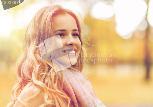 Image of beautiful happy young woman smiling in autumn park