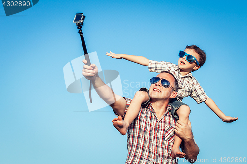 Image of Father and son playing in the park  at the day time. 