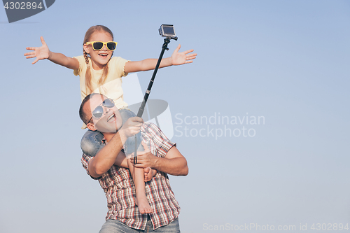 Image of Father and daughter playing in the park  at the day time.