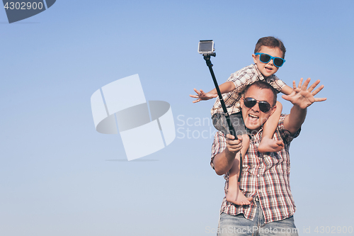 Image of Father and son playing in the park  at the day time.