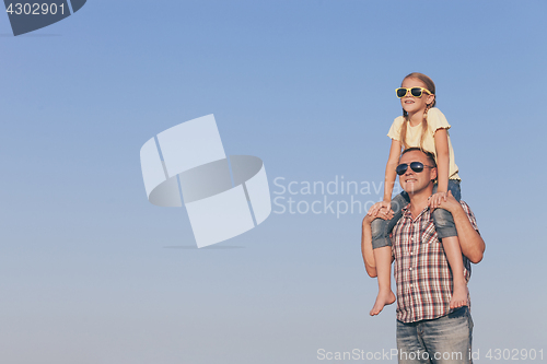 Image of Dad and daughter in sunglasses playing in the park at the day ti