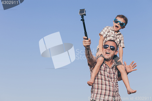 Image of Father and son playing in the park  at the day time.