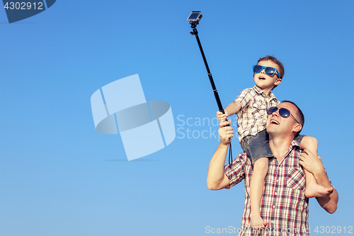 Image of Father and son playing in the park  at the day time.