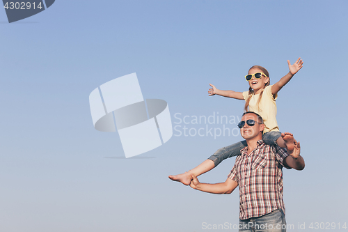 Image of Dad and daughter in sunglasses playing in the park at the day ti