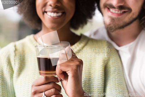 Image of happy multiethnic couple relaxing at modern home indoors