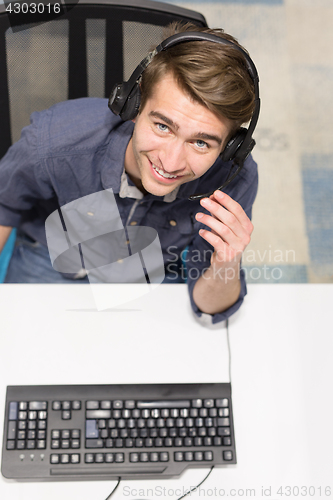 Image of male call centre operator doing his job top view