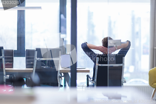 Image of young businessman relaxing at the desk