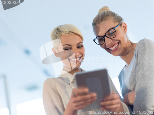 Image of Pretty Businesswomen Using Tablet In Office Building during conf