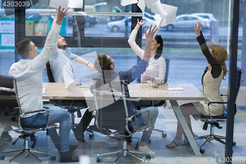 Image of startup Group of young business people throwing documents