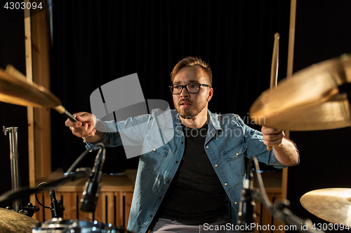 Image of male musician playing drums and cymbals at concert