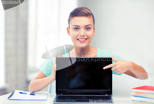 Image of smiling student girl with laptop at school