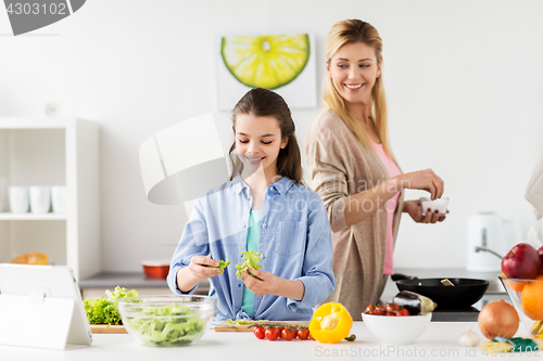 Image of happy family cooking salad at home kitchen