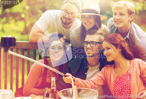 Image of friends taking selfie at party in summer garden