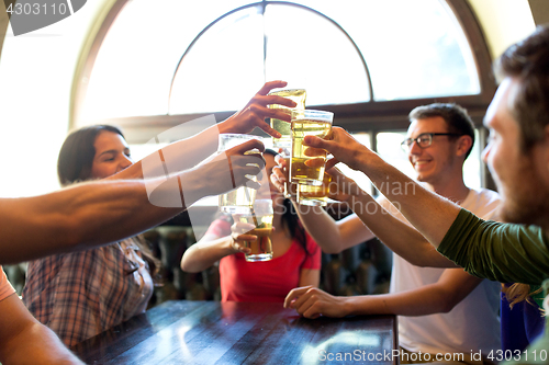 Image of happy friends drinking beer at bar or pub