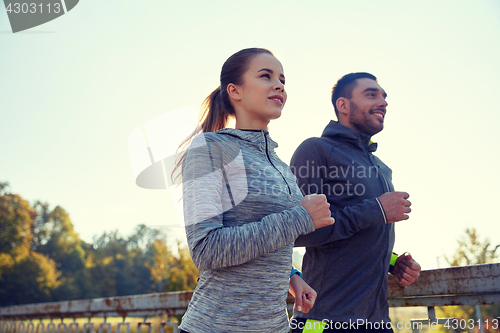 Image of happy couple running outdoors