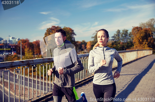 Image of happy couple running outdoors