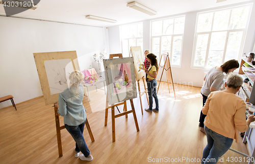 Image of woman artists with brushes painting at art school