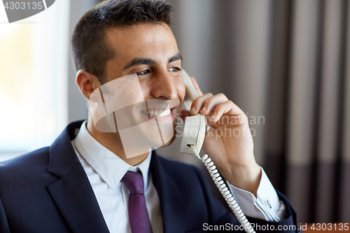 Image of businessman calling on phone at hotel or office 