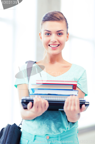 Image of student with folders and school bag in college